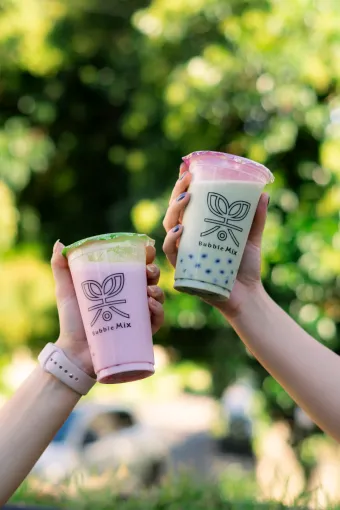 Cliente segurando um copo Bubble Mix Tea vermelho